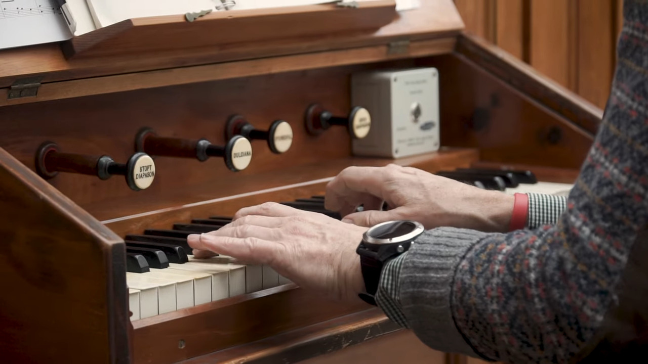 Closeup of hands playing the organ.
