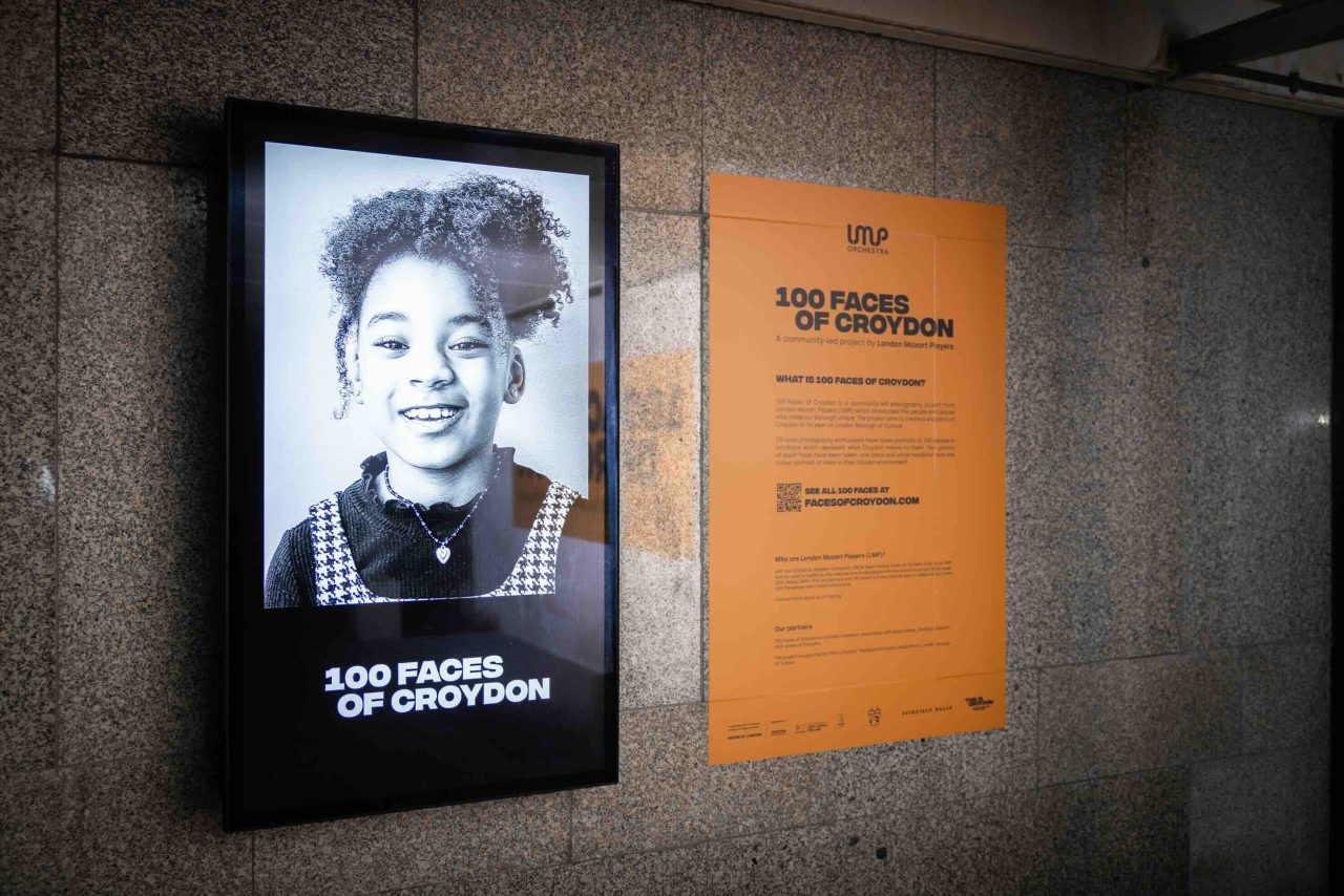 '100 Faces of Croydon' on an outdoor screen with information panel alongside.