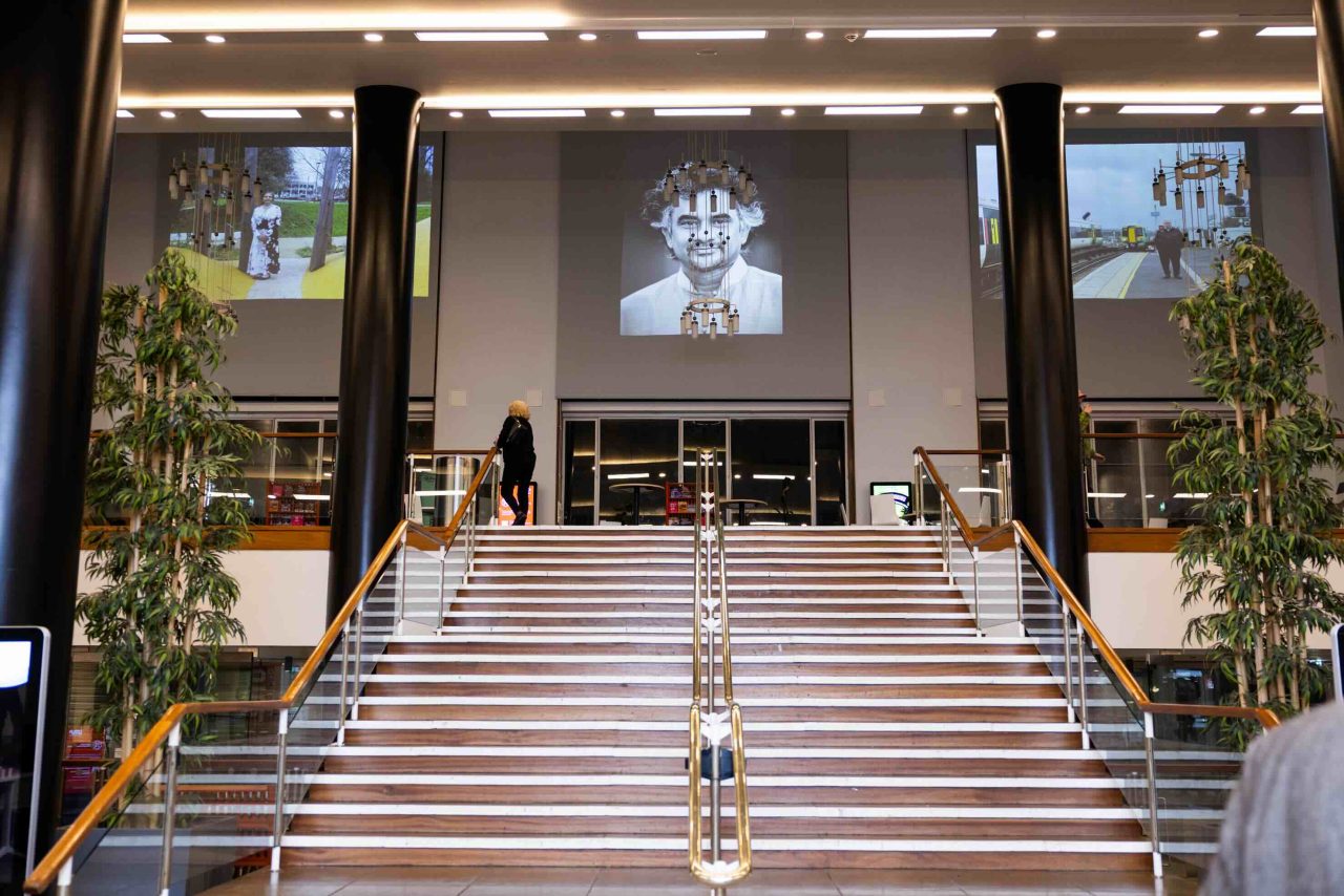 Photos projected above a concert hall foyer.