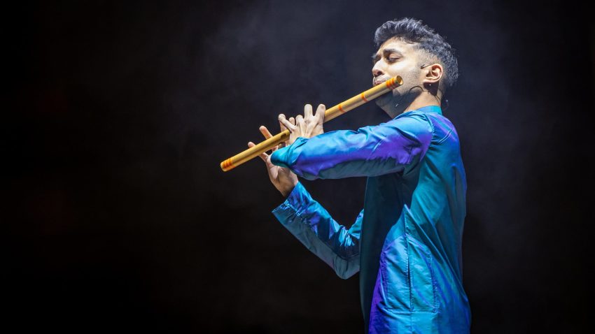 Man performs dramatically on traditional Indian flute.