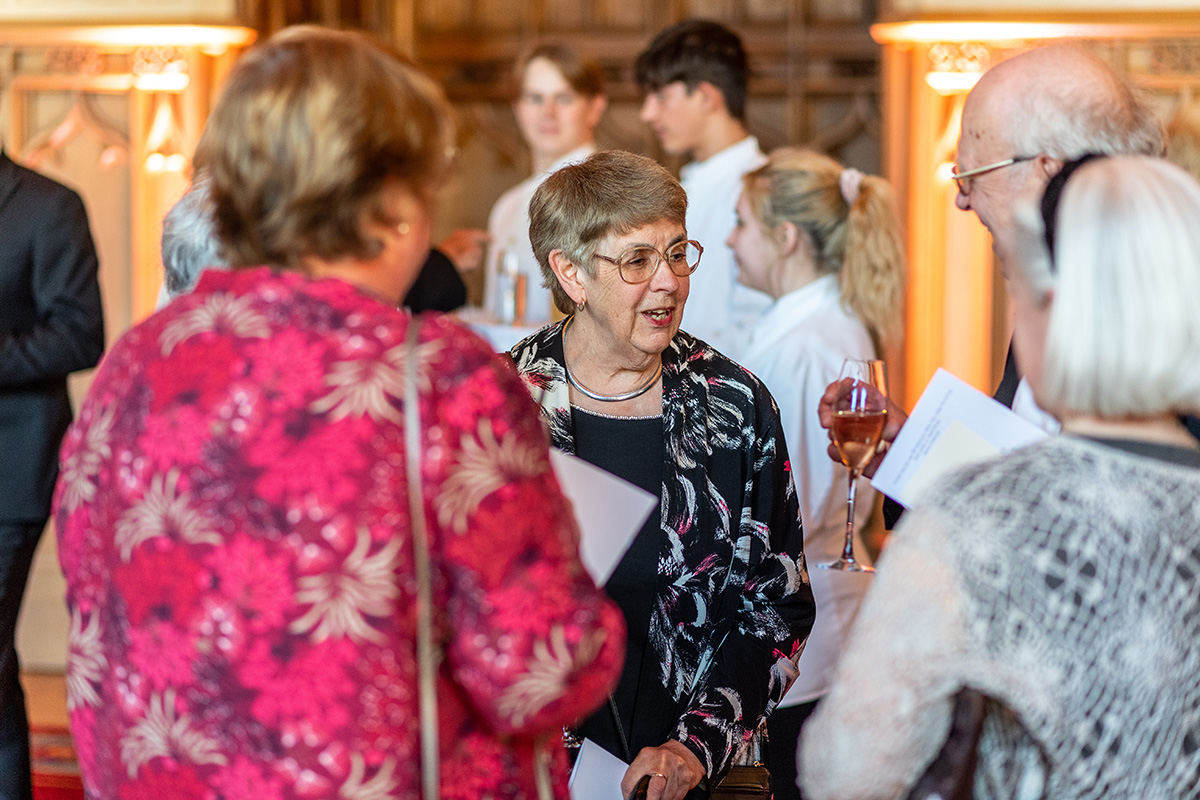A woman talks to a group of others at a reception.