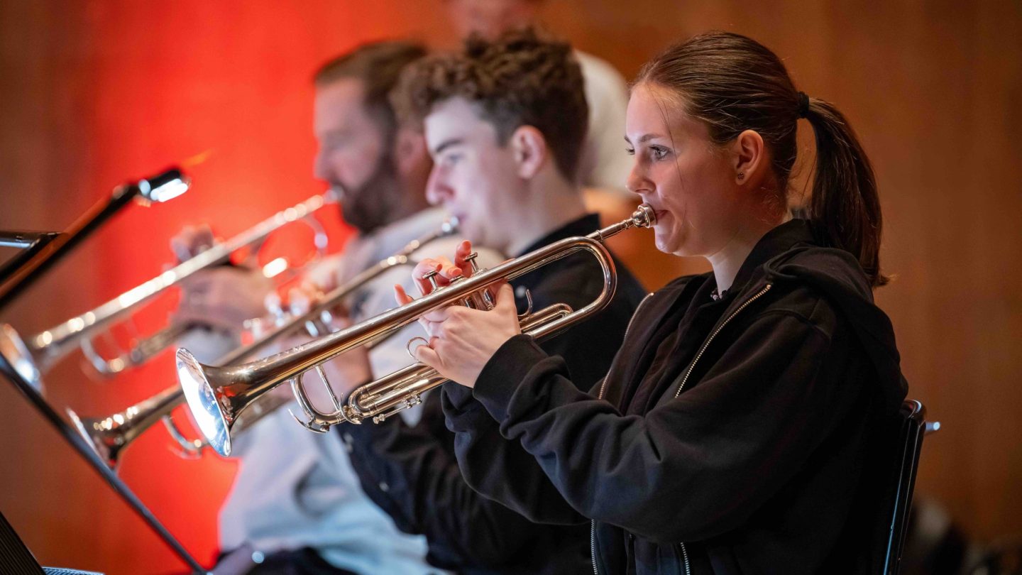 Young woman plays the trumpet.