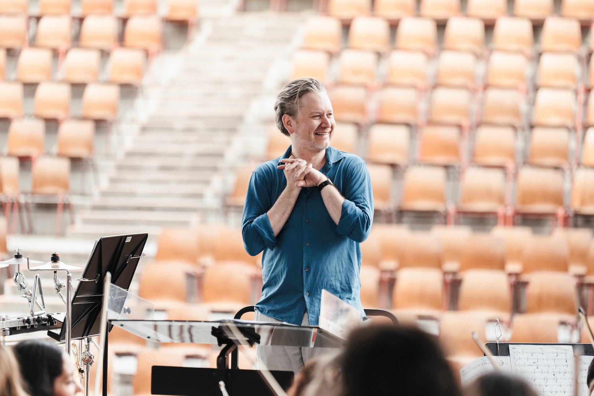 Jonathan smiles in from of concert hall seating.