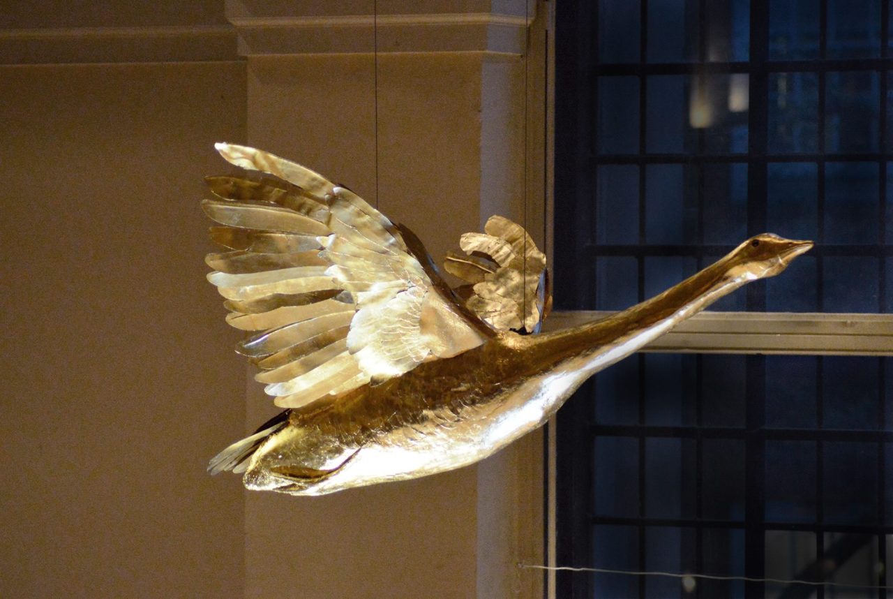 A model of a golden goose suspended from the ceiling.