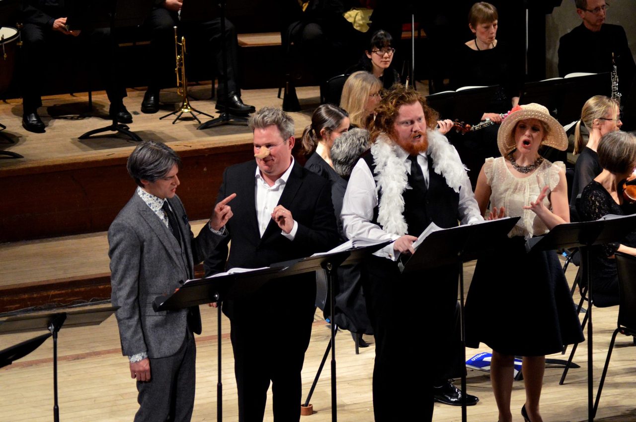 Singers perform wearing various items of fancy dress.